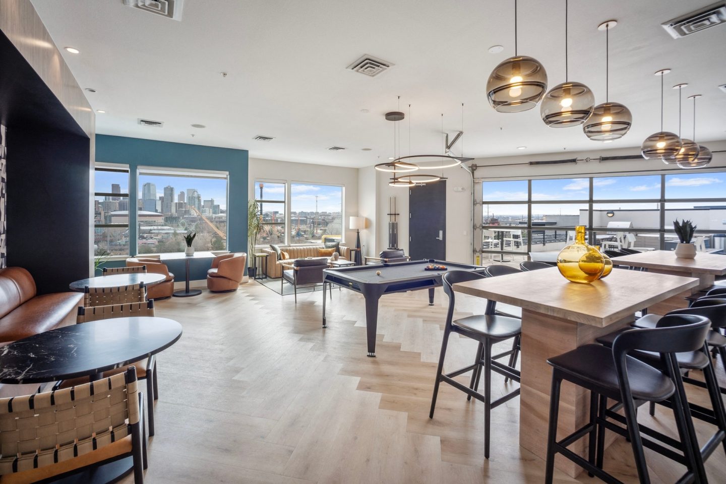 A modern living room with a pool table and a view of the city.