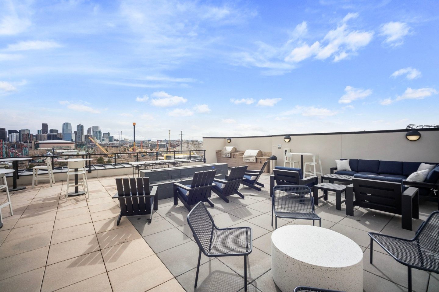 A patio with a table and chairs overlooking a city skyline.