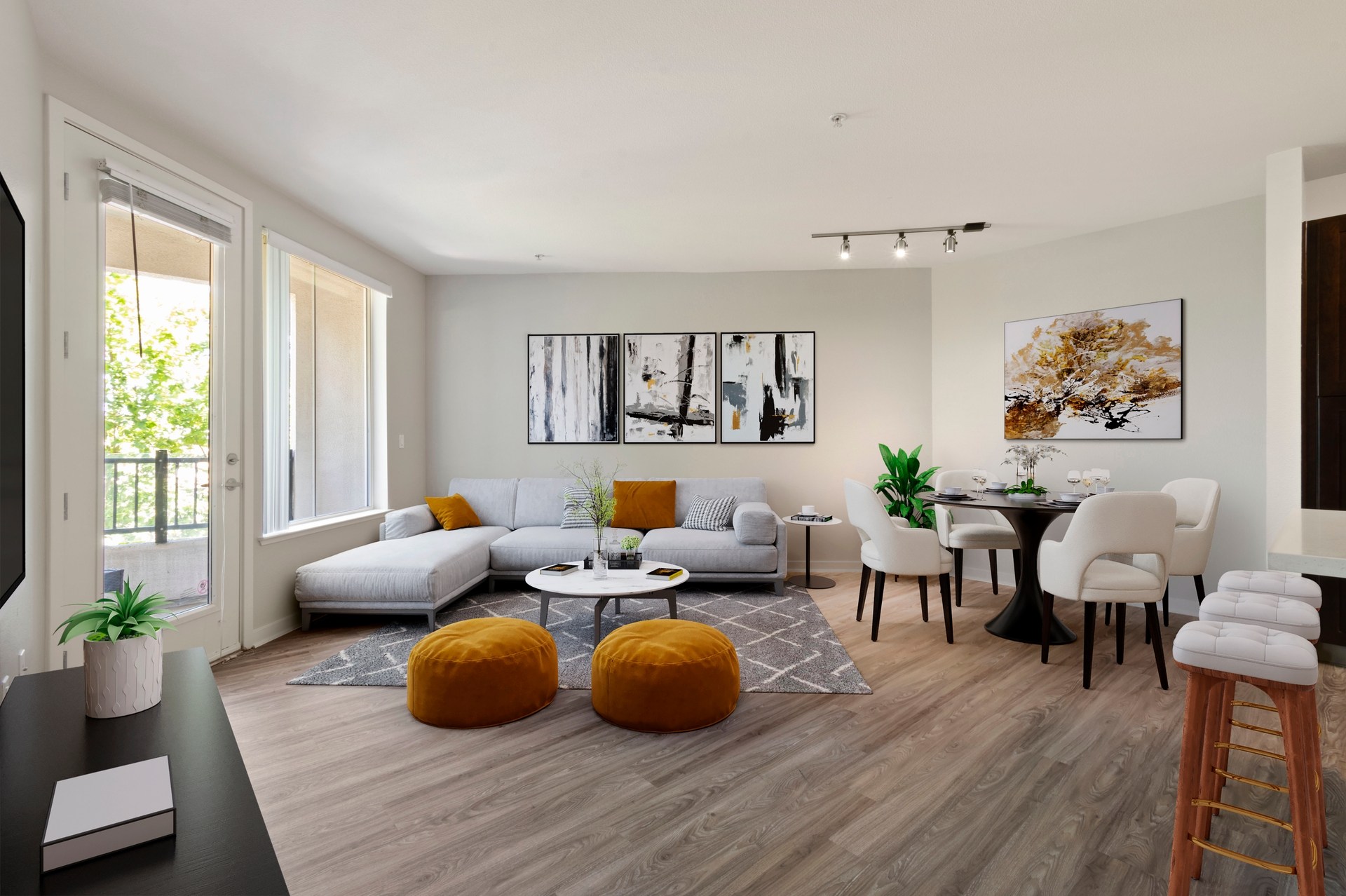 A modern living room with a grey sofa, a coffee table, and a dining table set up.