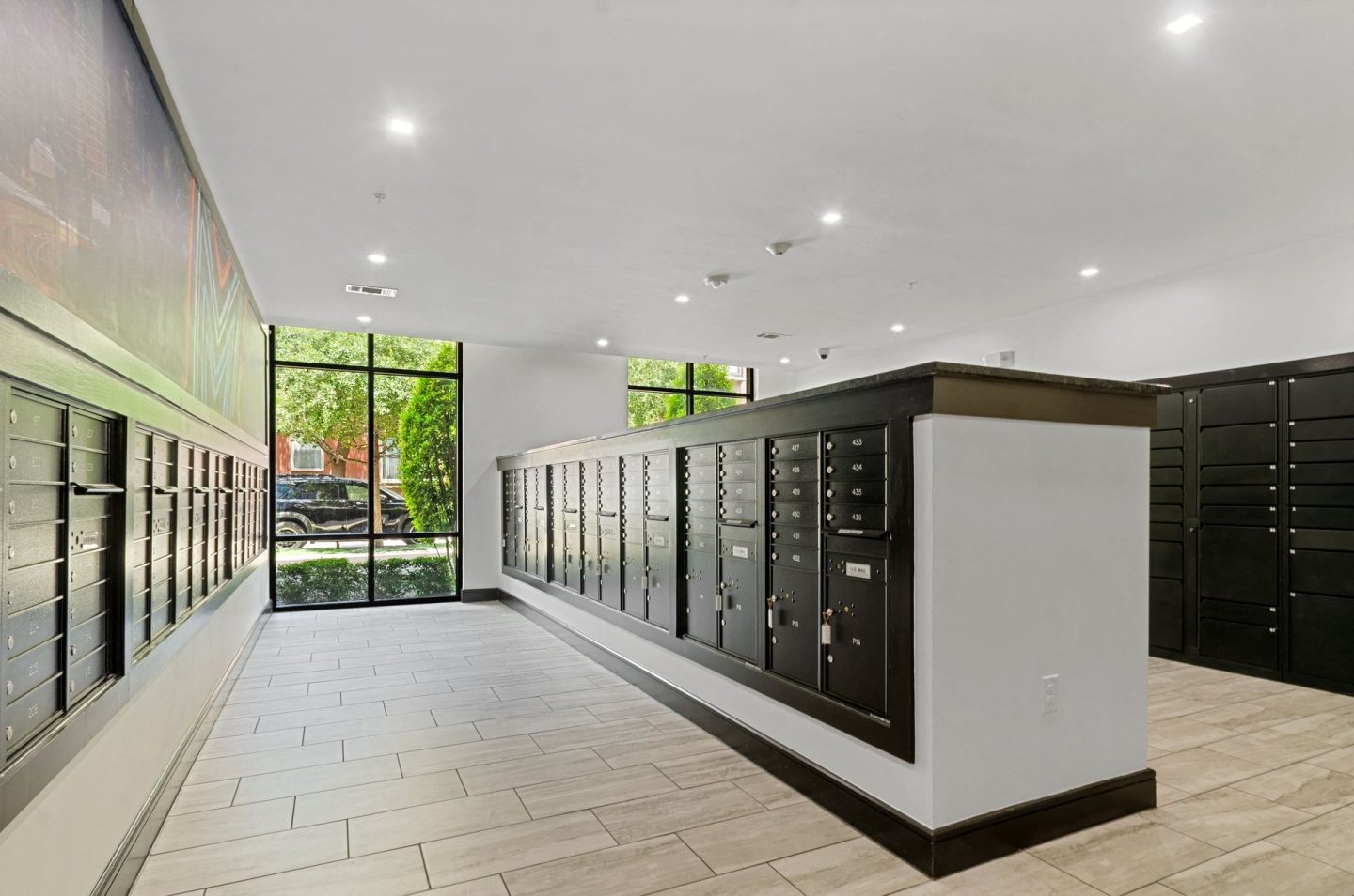 a large room with a wall of mailboxes and a large window