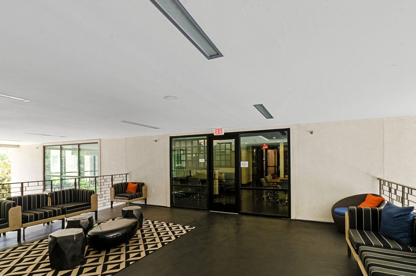 a lobby with couches and chairs and a glass door