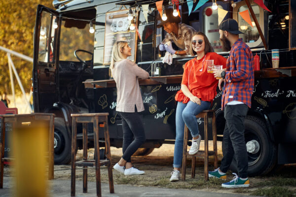customers of fast food truck having conversation between themselves and with employee