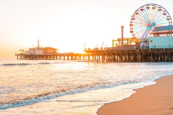 Santa Monica Pier on the background of an orange sunset, calm ocean waves, Los Angeles, California