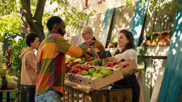 Female farmer giving free apple samples to clients for food tasting