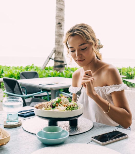 Woman eating salad in outdoors restaurant