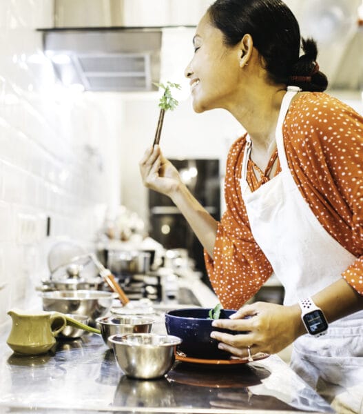 young woman tasting food from soup bowl
