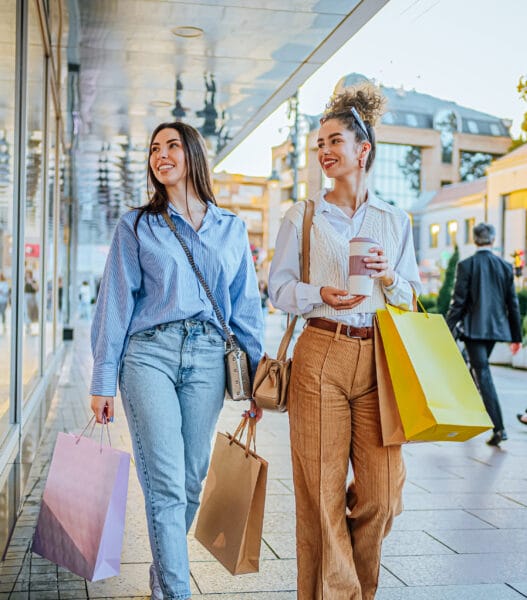 Female friends looking at store window