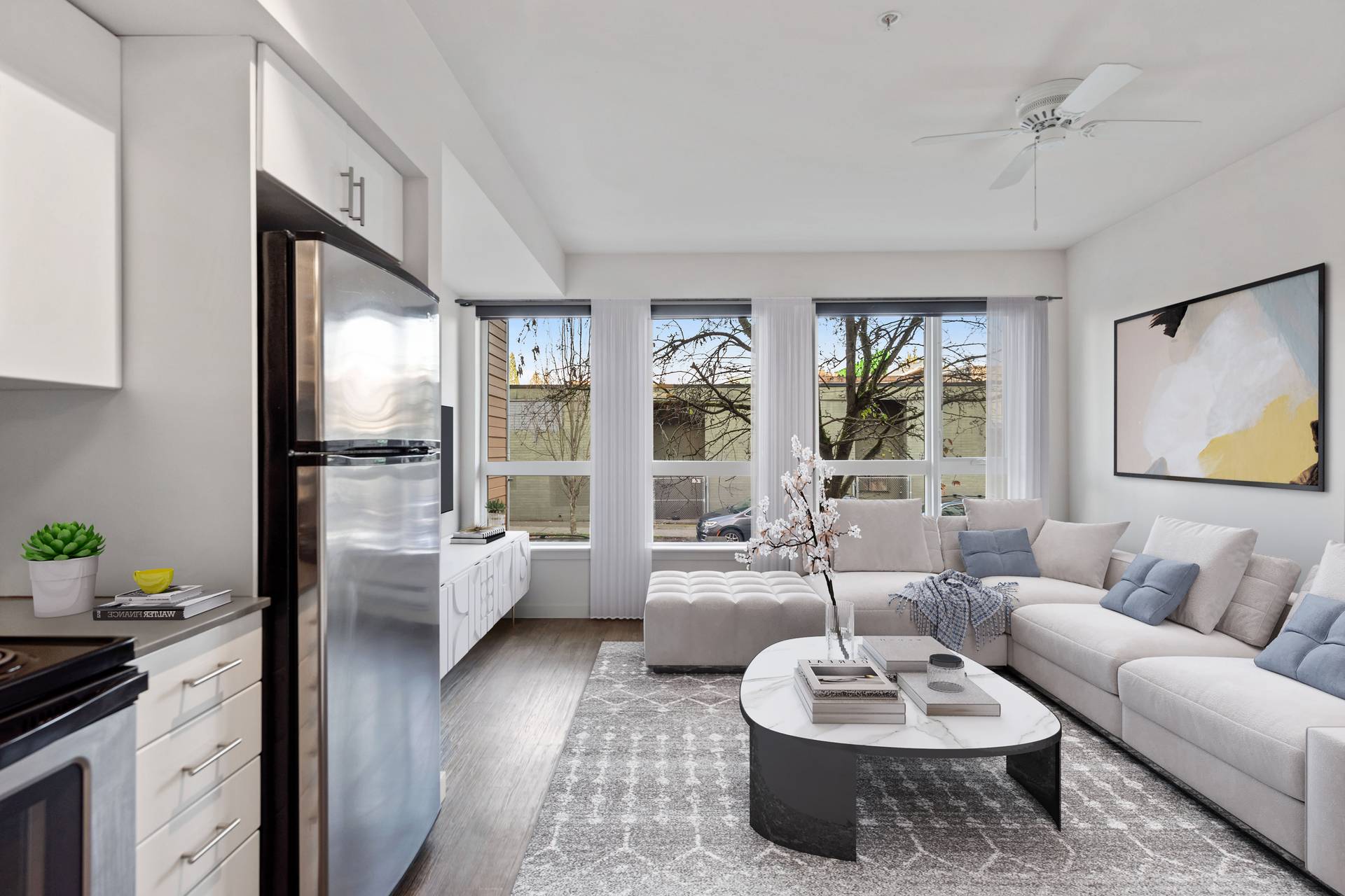 A modern kitchen with a refrigerator, a stove, a dining table, and a couch.
